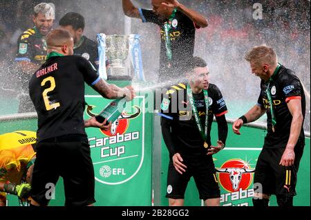 Le Kyle Walker de Manchester City (à gauche) pulvérise les coéquipiers Alexander Zinchenko (à droite) et Phil Foden avec du champagne lorsqu'ils célèbrent la victoire de la finale de la coupe Carabao au stade Wembley, à Londres. Banque D'Images