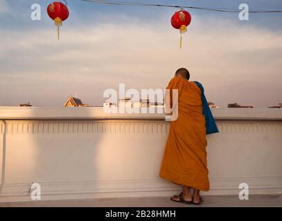 Le moine bouddhiste se trouve derrière le mur, donnant sur la rivière Chao Phraya à Bangkok, Thaïlande scène paisible avec moine bouddhiste Banque D'Images