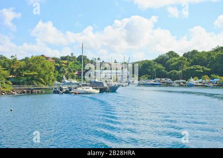 Vue enchanteresse de Port Castries, de petits bateaux et de bateaux ancrés en toute sécurité, des vagues de bateaux qui ont passé, des collines couvertes de vert en arrière-plan Banque D'Images