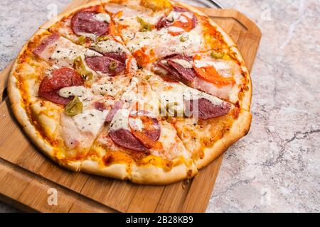 Pizza maison Avec pepperoni et fromage sur une planche à découper en bois sur la table de fermeture Banque D'Images