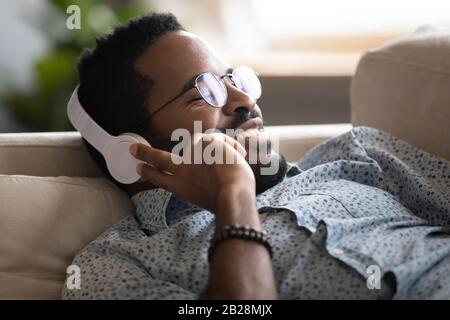 Heureux millénaire l'ethnicité africaine beau homme à l'écoute de la musique. Banque D'Images