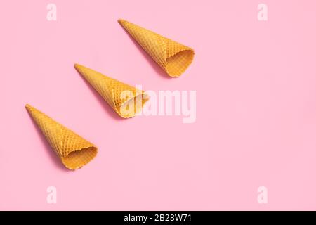 Videz les cônes de glace sur fond rose pâle. Plat avec espace de copie, motif Banque D'Images