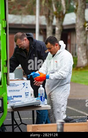 Les travailleurs ont des vêtements de protection et des masques avant d'entrer à l'école primaire de Forest Hills dans le lac Oswego, Oregon. Les autorités sanitaires de l'Oregon ont identifié un membre du personnel scolaire comme ayant un test positif de COVID-19 Ccoronavirus, vérifié par les Centres de contrôle des maladies à Atlanta. Lake Oswego School District Superentendent, le Dr Lora de la Cruz a déclaré que le "nettoyage en profondeur" de l'école est entrepris par mesure de précaution. Banque D'Images