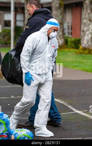 Les travailleurs ont des vêtements de protection et des masques avant d'entrer à l'école primaire de Forest Hills dans le lac Oswego, Oregon. Les autorités sanitaires de l'Oregon ont identifié un membre du personnel scolaire comme ayant un test positif de COVID-19 Ccoronavirus, vérifié par les Centres de contrôle des maladies à Atlanta. Lake Oswego School District Superentendent, le Dr Lora de la Cruz a déclaré que le "nettoyage en profondeur" de l'école est entrepris par mesure de précaution. Banque D'Images