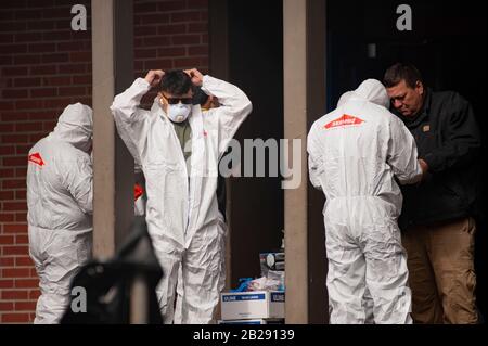 Les travailleurs ont des vêtements de protection et des masques avant d'entrer à l'école primaire de Forest Hills dans le lac Oswego, Oregon. Les autorités sanitaires de l'Oregon ont identifié un membre du personnel scolaire comme ayant un test positif de COVID-19 Ccoronavirus, vérifié par les Centres de contrôle des maladies à Atlanta. Lake Oswego School District Superentendent, le Dr Lora de la Cruz a déclaré que le "nettoyage en profondeur" de l'école est entrepris par mesure de précaution. Banque D'Images