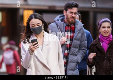 Centre de Londres, Royaume-Uni 1 mars 2020 - une femme asiatique portant un masque chirurgical dans Chinatown par mesure de précaution contre le nouveau type de coronavirus (COVID-19) son vu regarder un téléphone mobile. Douze personnes de plus ont testé positif pour le coronavirus au Royaume-Uni, portant le nombre total de cas à 35. Crédit: Dinendra Haria/Alay Live News Banque D'Images