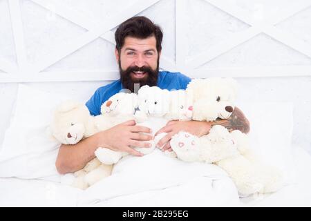 De retour dans l'enfance. Joyeux anniversaire. Homme avec barbe heureux visage tenir des jouets cadeaux. Boutique de jouets. Baccalauréat. Habitudes Puériles. Ours en peluche. Achats en ligne. Jouets pour adultes. Détendez-vous dans la chambre. Banque D'Images