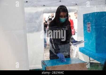 Tel Aviv, Israël. 1 mars 2020. Un membre du personnel montre comment voter dans un bureau de vote spécial pour les électeurs mis en quarantaine en raison de l'exposition au coronavirus, dans la ville israélienne centrale de tel Aviv, le 1er mars 2020. Israël se préparait dimanche à des élections parlementaires répétées sans précédent lundi, pour la troisième fois en moins d'un an. Quelque 14 bulletins de vote spéciaux seront établis pour l'utilisation de centaines d'Israéliens qui sont soumis à l'autoquarantaine obligatoire par crainte qu'ils aient été infectés par la COVID-19. Crédit: Xinhua/Alay Live News Banque D'Images