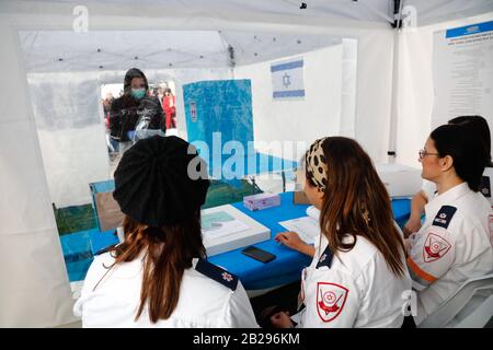 Tel Aviv, Israël. 1 mars 2020. Les membres du personnel montrent comment voter dans un bureau de vote spécial pour les électeurs mis en quarantaine en raison de l'exposition au coronavirus, dans la ville israélienne centrale de tel Aviv, le 1er mars 2020. Israël se préparait dimanche à des élections parlementaires répétées sans précédent lundi, pour la troisième fois en moins d'un an. Quelque 14 bulletins de vote spéciaux seront établis pour l'utilisation de centaines d'Israéliens qui sont soumis à l'autoquarantaine obligatoire par crainte qu'ils aient été infectés par la COVID-19. Crédit: Xinhua/Alay Live News Banque D'Images