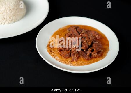 Plat grec Stifado, fait avec de l'agneau et servi avec de la salade grecque. Peut également être fait avec du boeuf ou du gibier, ragoût de boeuf, goutte de boeuf, bourguignon de boeuf Banque D'Images