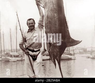 Ernest Hemingway (1899-1961) posant avec un makaire au port de la Havane, Cuba, juillet 1934. Banque D'Images