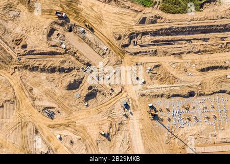 pelles hydrauliques et chargeurs de camions effectuant des travaux de terrassement avant la construction de bâtiments. vue aérienne Banque D'Images