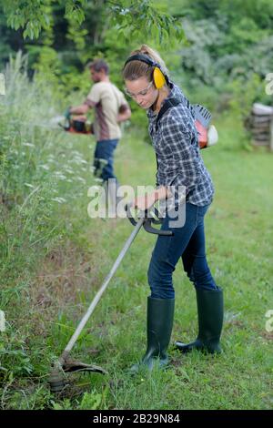 Portrait of woman cutting grass Banque D'Images