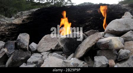 Salon dans la roche. Les feux d'émerveillement brûlent depuis au moins 2500 ans, donc certaines pierres sont noires. Mont Chimera (Antalya, Turquie). Banque D'Images