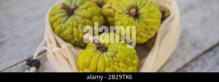 Cherimoya dans un sac réutilisable sur une élégante surface de cuisine en bois. Concept zéro déchet, concept sans plastique. Saine alimentation propre et détox. Été Banque D'Images