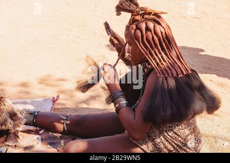 Namibie, KAMANJAB, 6 MAI: Ennuyer des femmes Himba dans le village posant aux touristes près de Kamanjab dans le nord de la Namibie, 6 mai 2018, Namibie Banque D'Images