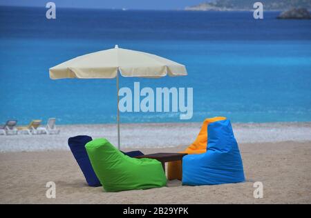 Sièges multicolores lumineux et parasols sur la plage. Plage équipée de sable. Mer bleue à l'arrière-plan. Banque D'Images