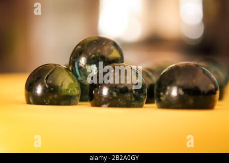 Boule en marbre vert en verre simple avec une belle ombre et une lumière impressionnante avec un fond flou Banque D'Images