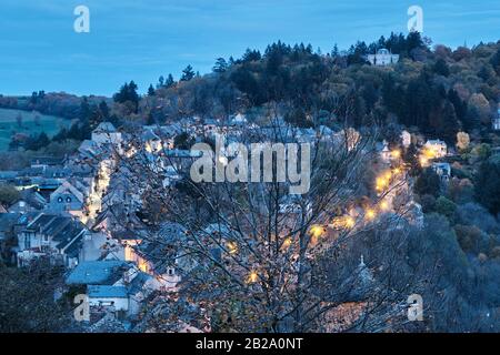 Petite ville illuminée et enveloppée par un arbre au premier plan, Najac, France Banque D'Images