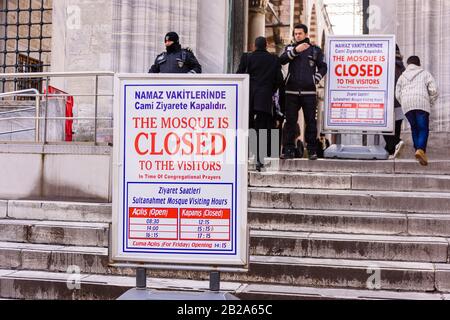 La police se tient derrière un panneau à l'extérieur de la Mosquée bleue disant que la mosquée est fermée aux visiteurs pendant la prière. Istanbul, Turquie Banque D'Images
