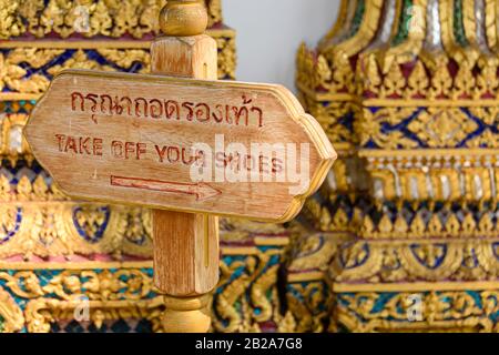 Signe à un temple bouddhiste demandant aux gens de retirer leurs chaussures, Wat Pho, Bangkok, Thaïlande Banque D'Images