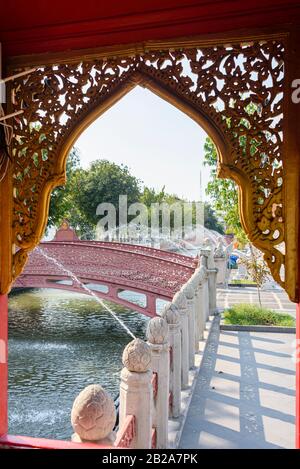 Fontaines au-dessus du canal avec un pont en fonte rouge, Wat Benchamabophit (le Temple du marbre), Bangkok, Thaïlande. Banque D'Images