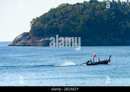 Longboat naviguant au-delà d'une île en Thaïlande. Banque D'Images