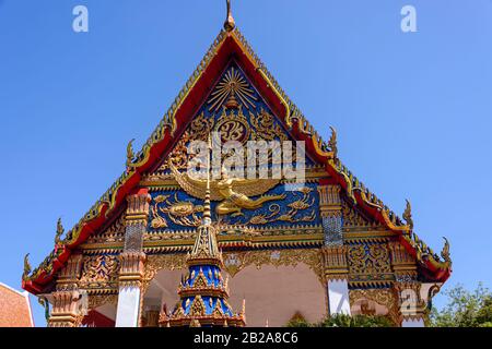 Toit orné et décorations de statue dorée au temple bouddhiste Wat Mongkhon Nimit, dans la vieille ville de Phuket, en Thaïlande Banque D'Images