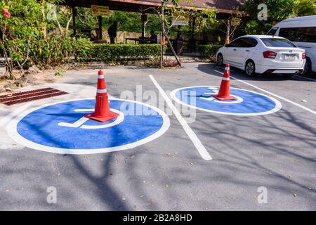 Trafic Cones sur des marquages de route fraîchement peints pour les places de stationnement pour personnes à mobilité réduite. Banque D'Images