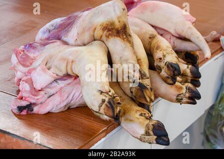 Les pieds de porc trotters en vente au stand de bouchers dans le marché Frais traditionnel Mae Somchit Kata, Kata, Phuket, Thaïlande Banque D'Images