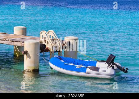 Bateau de pêche flottant sur la mer près de la jetée avec escaliers Banque D'Images