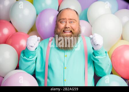 Portrait de l'homme énergique et ébloui grand ventre recevoir envie cadeau présent gagner élever les poings porter des vêtements roses sarcelle brillant sur l'air Banque D'Images