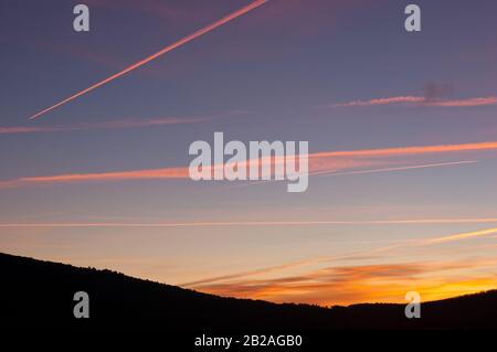 Rose contraste au lever du soleil avec la montagne en silhouette Banque D'Images