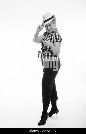 Full body shot of happy senior Asian woman smiling while holding hat et doigt contre fond blanc Banque D'Images