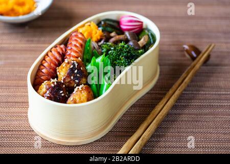 Boîte à bento japonaise avec boulettes de viande, saucisses et légumes Banque D'Images