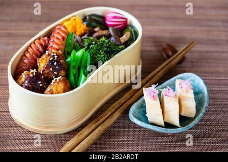 Boîte à bento japonaise avec boulettes de viande, saucisses et légumes Banque D'Images