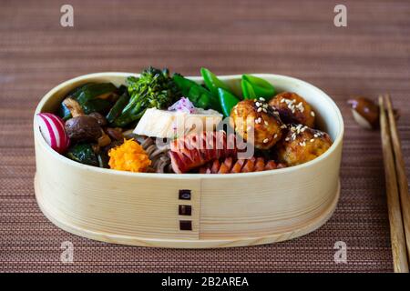 Boîte à bento japonaise avec boulettes de viande, saucisses et légumes Banque D'Images