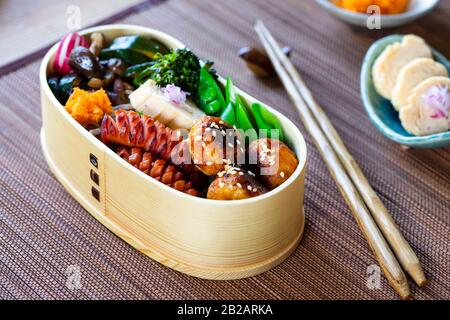 Boîte à bento japonaise avec boulettes de viande, saucisses et légumes Banque D'Images