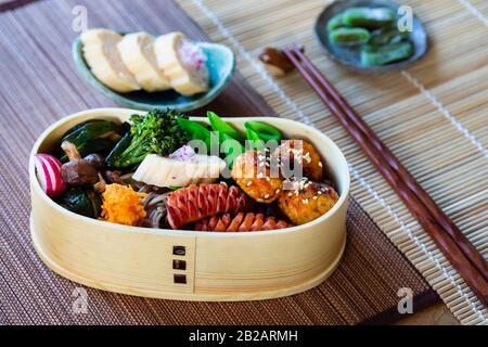 Boîte à bento japonaise avec boulettes de viande, saucisses et légumes Banque D'Images