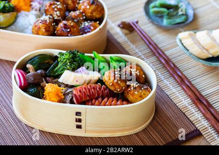 Boîte à bento japonaise avec boulettes de viande, saucisses et légumes Banque D'Images