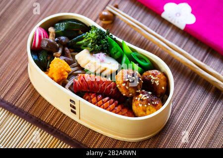 Boîte à bento japonaise avec boulettes de viande, saucisses et légumes Banque D'Images