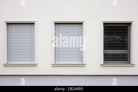 Trois fenêtres dans un bâtiment de style contemporain. Deux d'entre eux ont les stores fermés. Banque D'Images