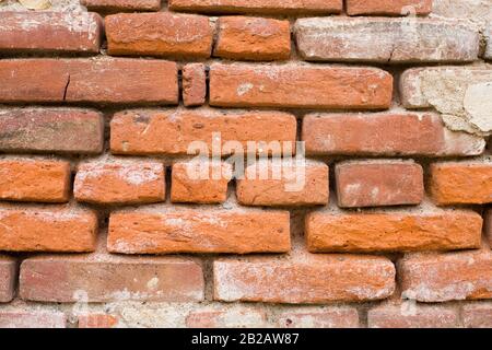 Photo d'un vieux mur de briques. Les briques sont très texturées et tissées. Banque D'Images