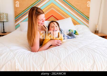 Portrait d'une mère et d'une fille posée sur un lit parlant