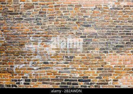 Photo d'un vieux mur de briques. Les briques sont très texturées et tissées. Banque D'Images