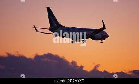 Le 29 février 2020, Richmond (Colombie-Britannique), Canada : un Boeing 737-700 (C-FWSV) de WestJet à allée simple au coucher du soleil, aéroport international de Vancouver. (Image De Crédit : © Bayne Stanley/Zuma Wire) Banque D'Images