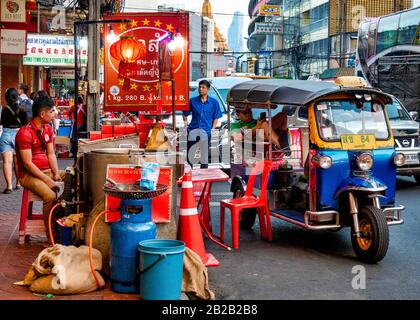 Le chauffeur de tuk Tuk se repose près d'un stand de restauration dans la rue Yaowarat Road, Bangkok, Thaïlande Banque D'Images