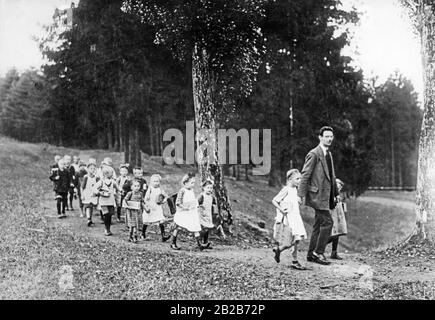 Un professeur avec sa classe d'école primaire lors d'une sortie d'été. La photo n'est pas datée. Banque D'Images