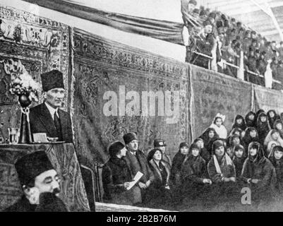 Mustafa Kemal Atatuerk au pupitre du premier congrès des femmes de l'histoire turque à Izmir. Latife Hanim, sa femme, est assise à droite et prend note de son discours. Photo non datée. Banque D'Images