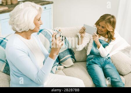 Grand-Mère Et Petite-Fille Qui Font Des Photos En Utilisant Différentes Technologies Banque D'Images